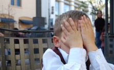 Kind mit Händen vor dem Gesicht