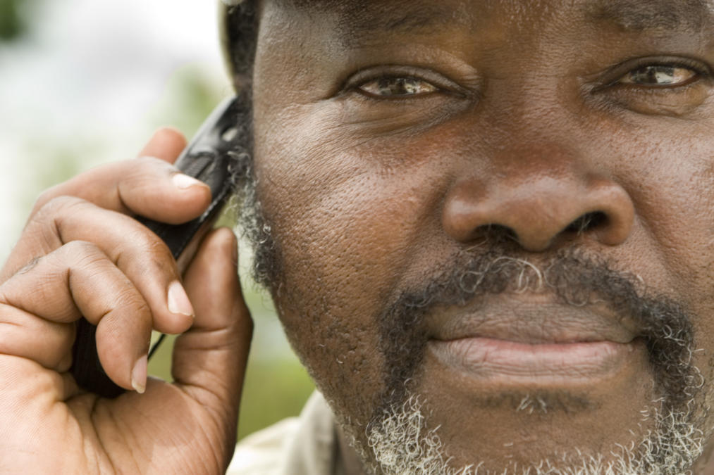 Ein Mann hält sich ein Handy ans Ohr.