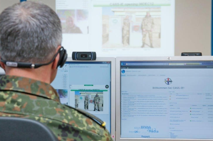 Ein Mann in Bundeswehr-Uniform sitzt vor PC-Bildschirmen