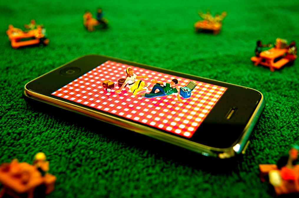 Zwei Menschen machen ein Picknick auf einem Smartphone.