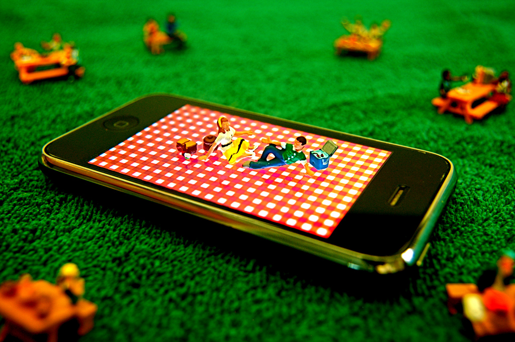 Zwei Menschen machen ein Picknick auf einem Smartphone.