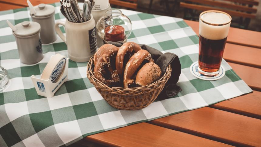 Bier und Brezeln auf einer karrierten Tischdecke