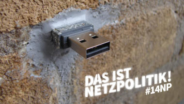 Foto eines USB-Sticks, der in eine Wand betoniert wurde. Weißer Schriftzug: "Das ist Netzpolitik! #14np"