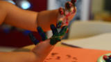 Kinderhände mit bunten Fingerfarben