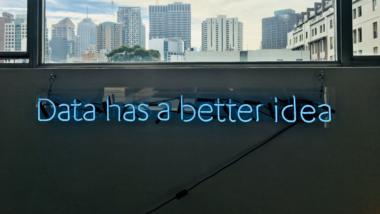 Ein blauer Neon-Schriftzu auf einer Wand liest "Data has a better idea"