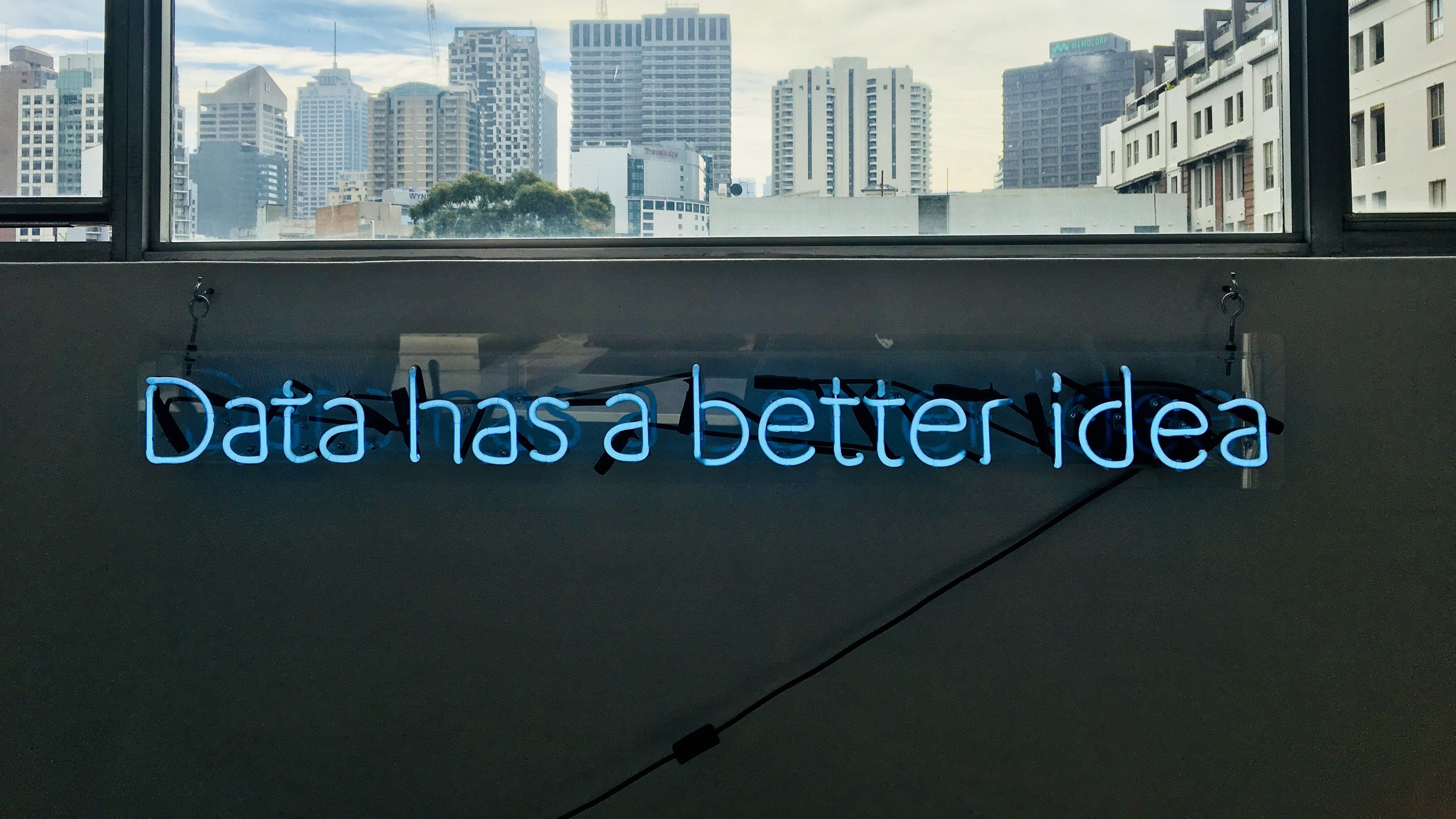 Ein blauer Neon-Schriftzu auf einer Wand liest "Data has a better idea"