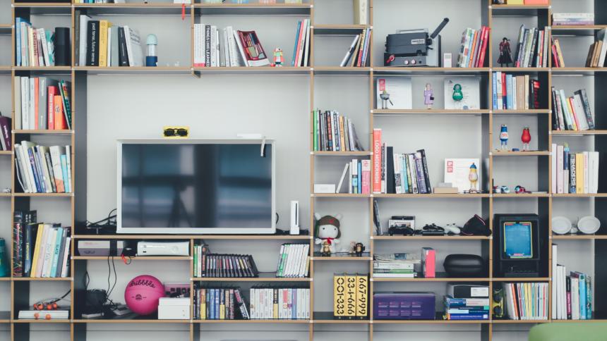 Wohnzimmer-Regal mit Flachbildschirm, Büchern und Gadgets.