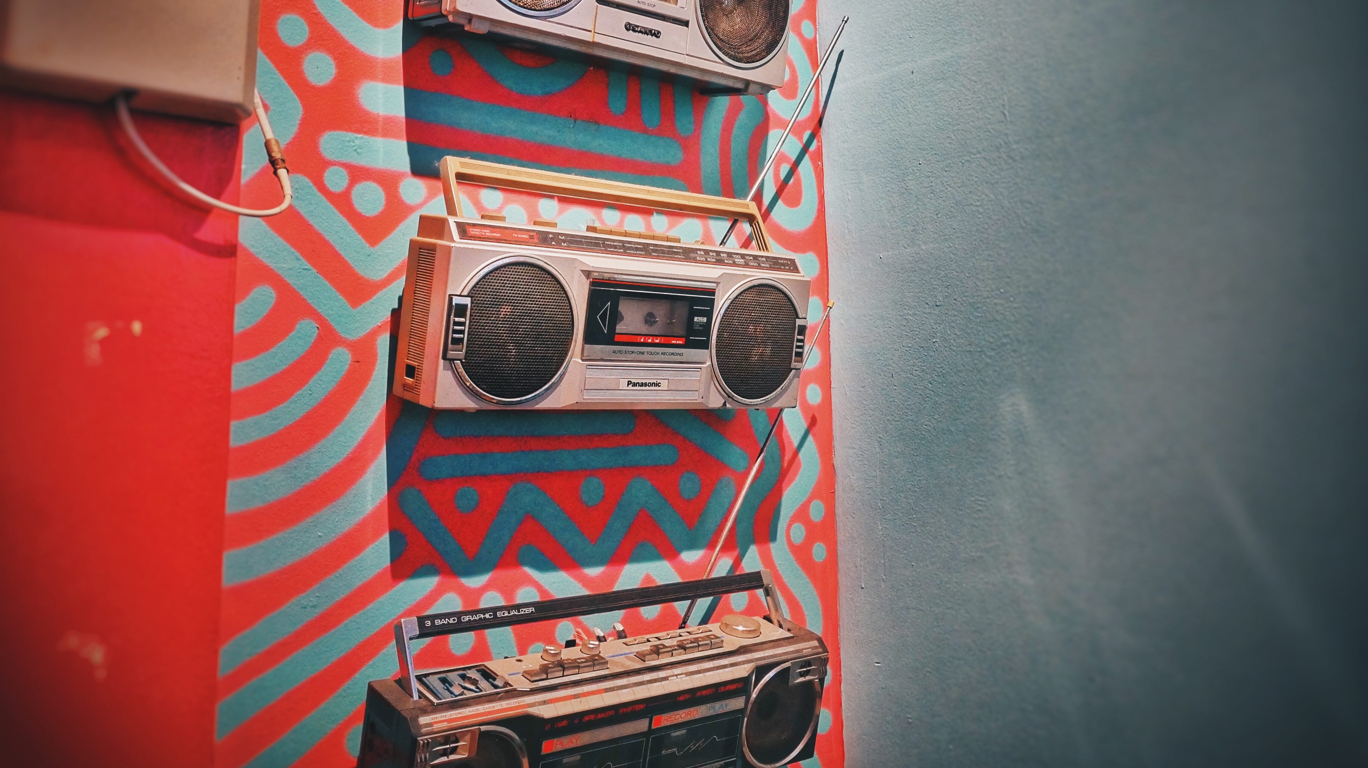 Ein Radio hängt an einer rot gemusterten Wand