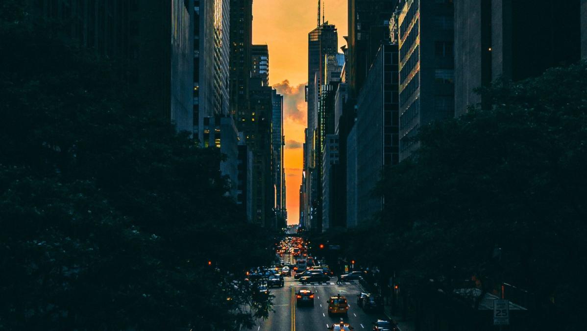 Bild einer großen Straße im Dunkeln, am Ende leuchtet der Himmel