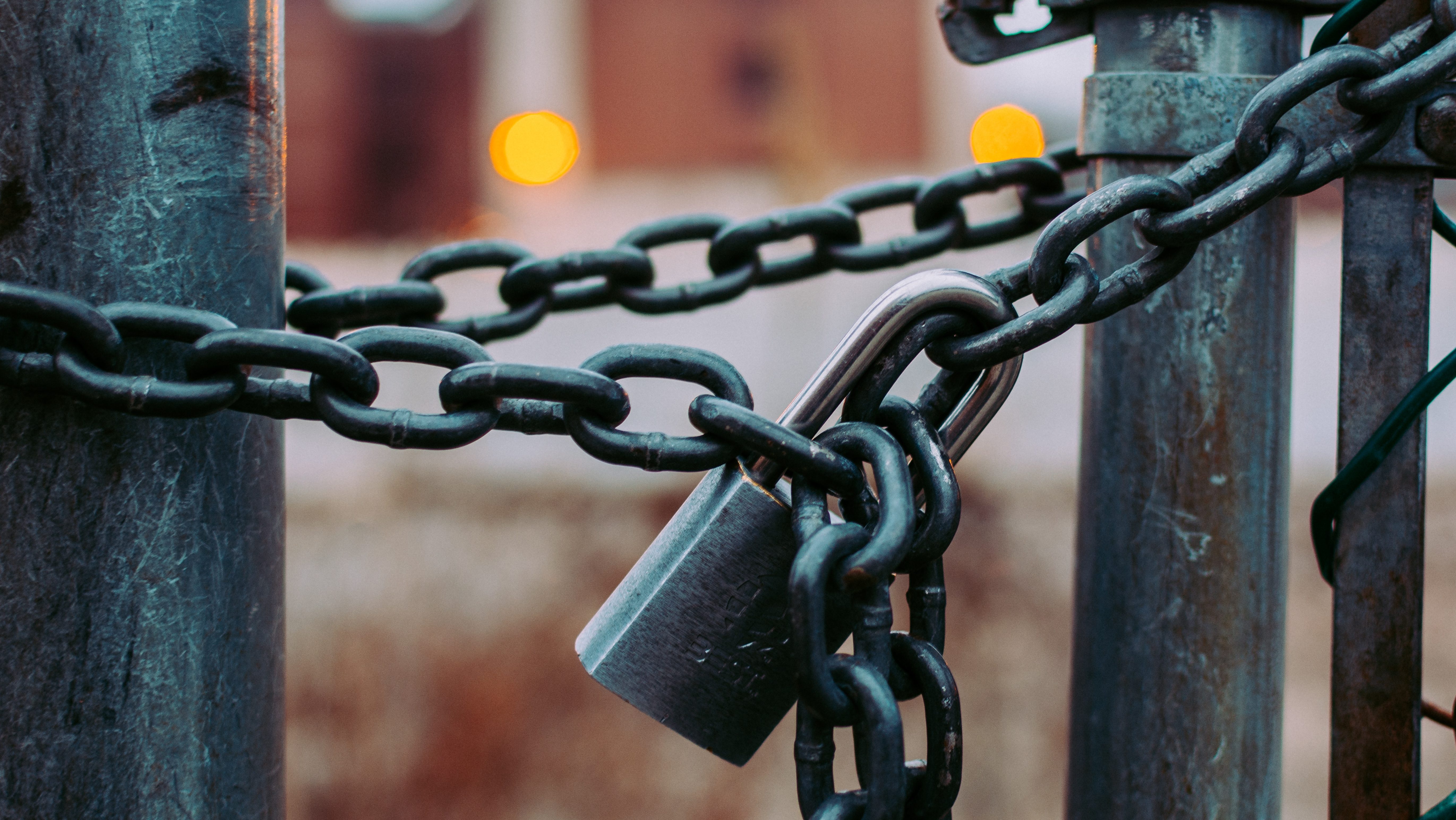 Ein Tor, das mit einer Metallkette und einem Vorhängeschloss verschlossen ist