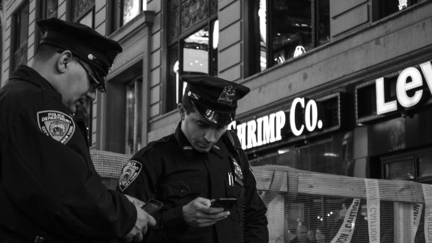 Zwei Polizisten schauen auf ihre Smartphones