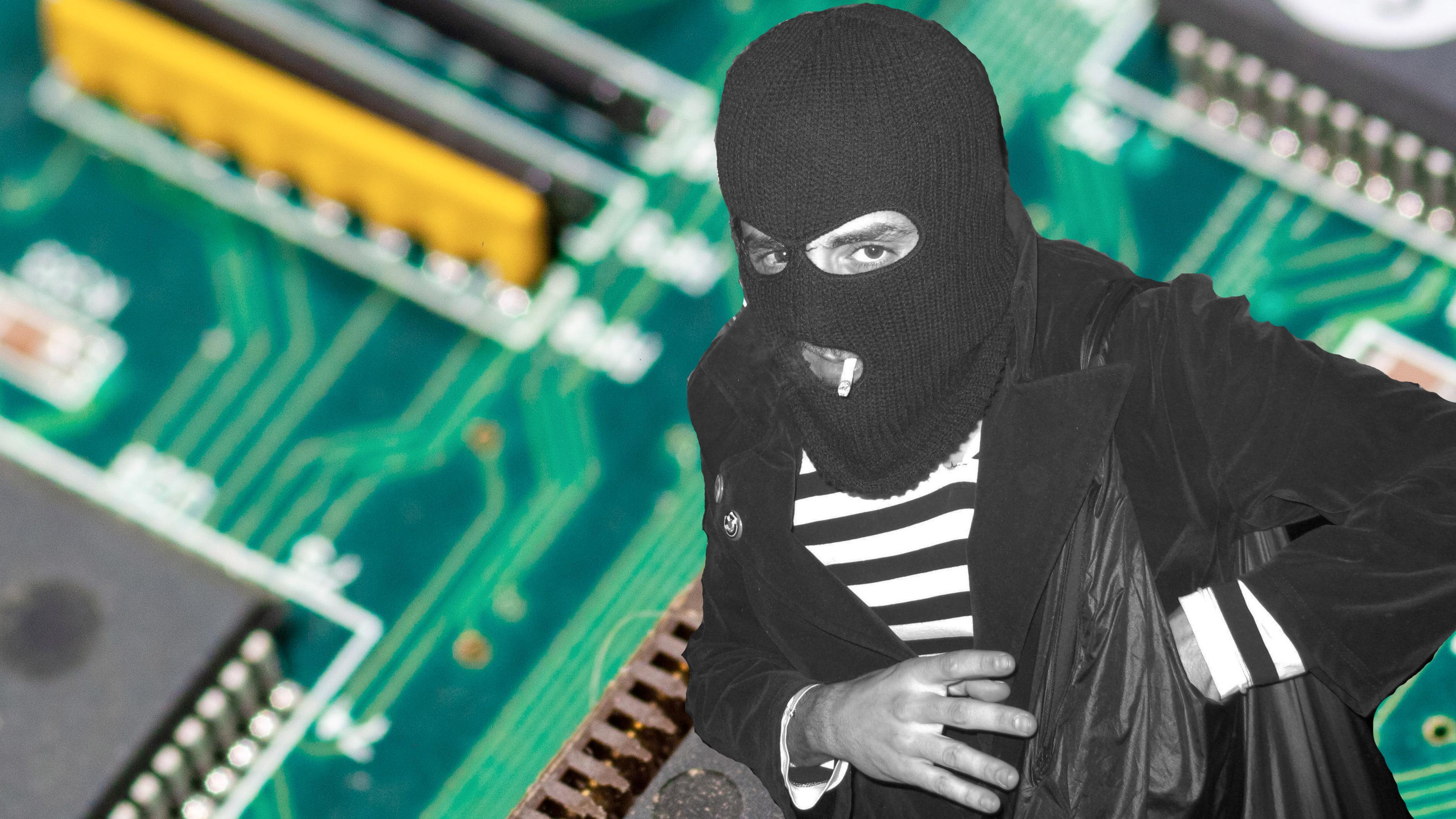 Mann mit Sturmhaube, im Hintergrund eine Platine mit Computerchips