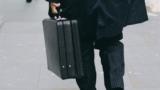 Ein Mann im Anzug mit Koffer