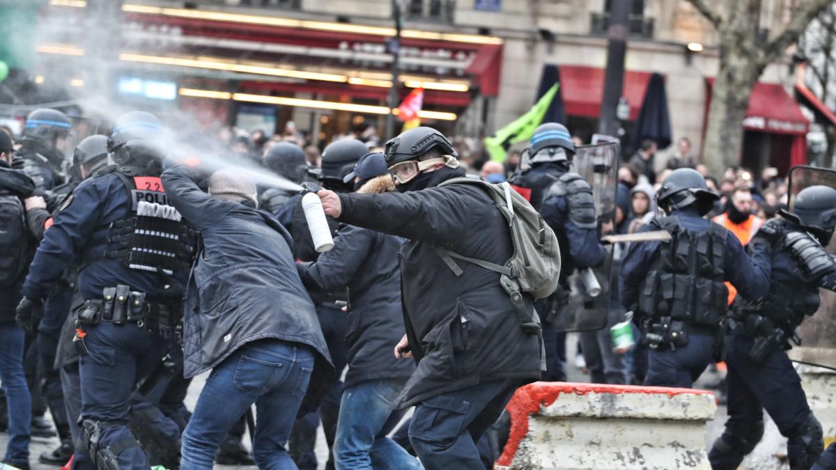 Demonstrant*innen und Polizist*innen auf Straßenprotest