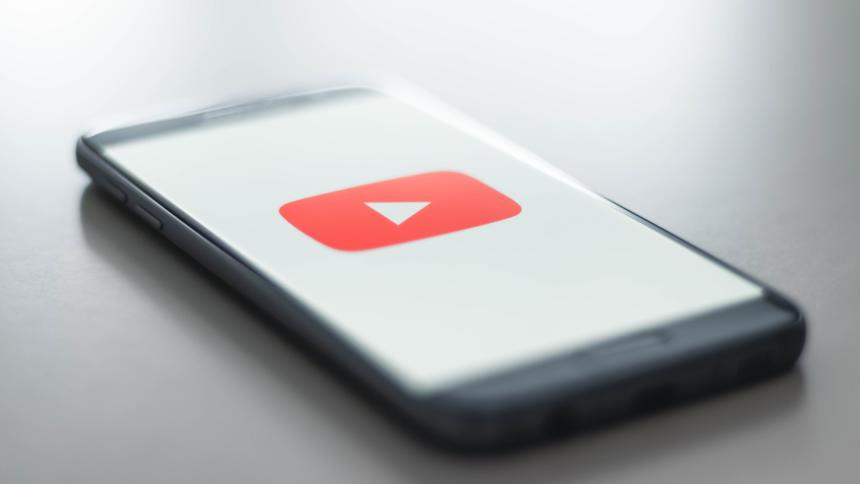 Smartphone, Bildschirm zeigt YouTube-Logo auf weißem Hintergrnud