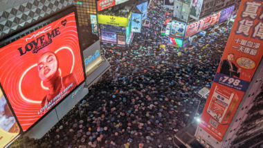 Proteste in Hongkong, im Hitergrund Werbetafeln und Hochhäuser