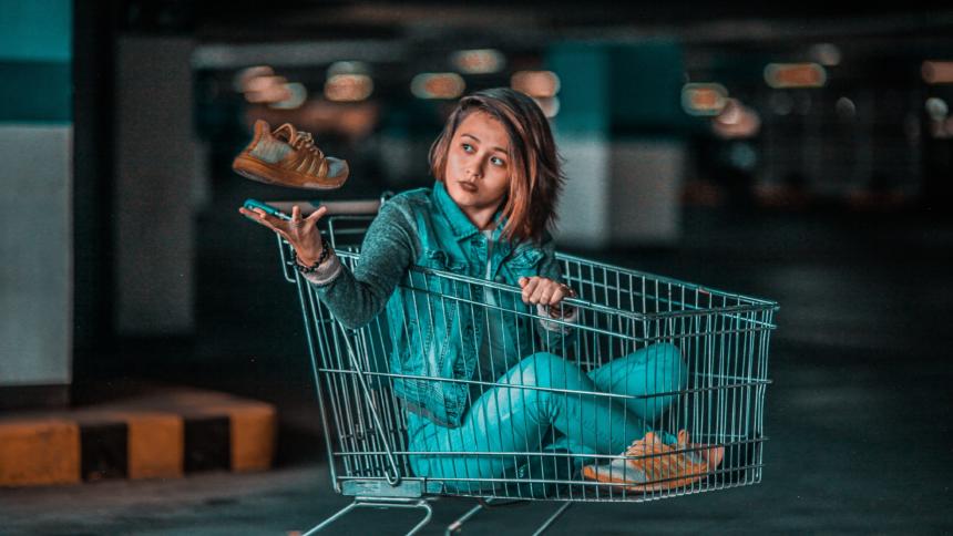 Frau sitzt in einem Einkaufswagen