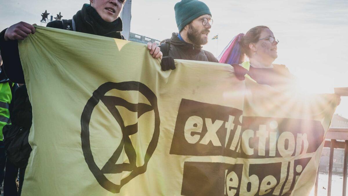 Menschen tragen ein Transparent mit der Aufschrift "Extinction Rebellion"