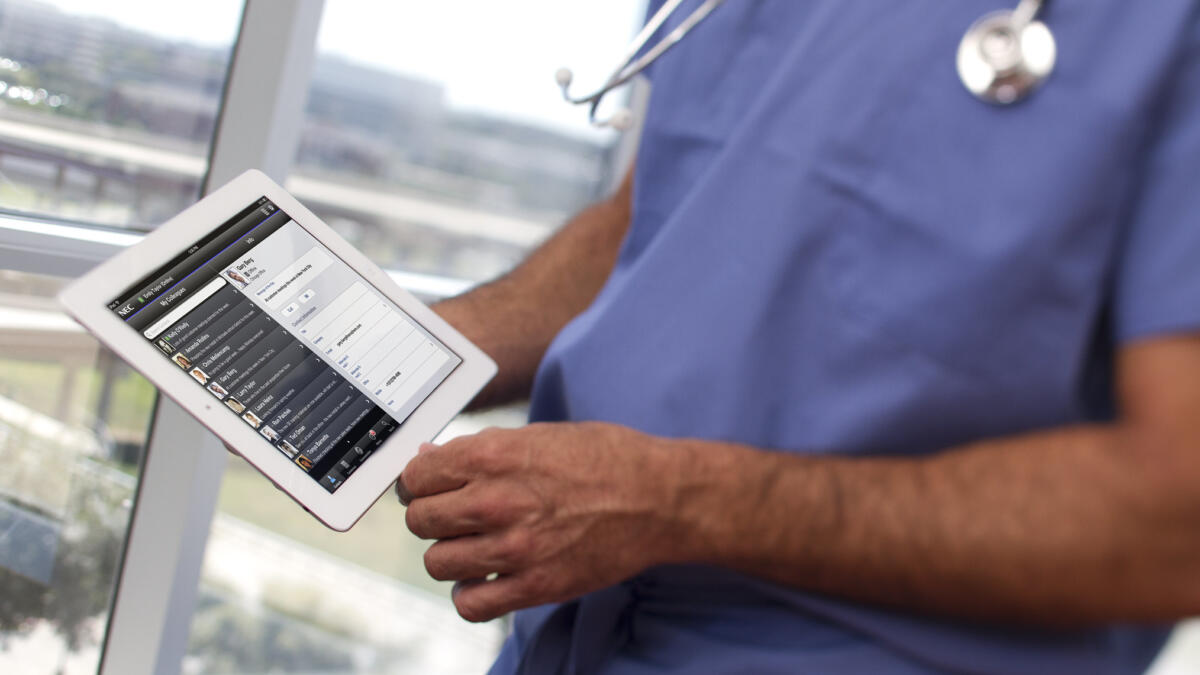 Ein Mensch im Arztkittel mit Tablet