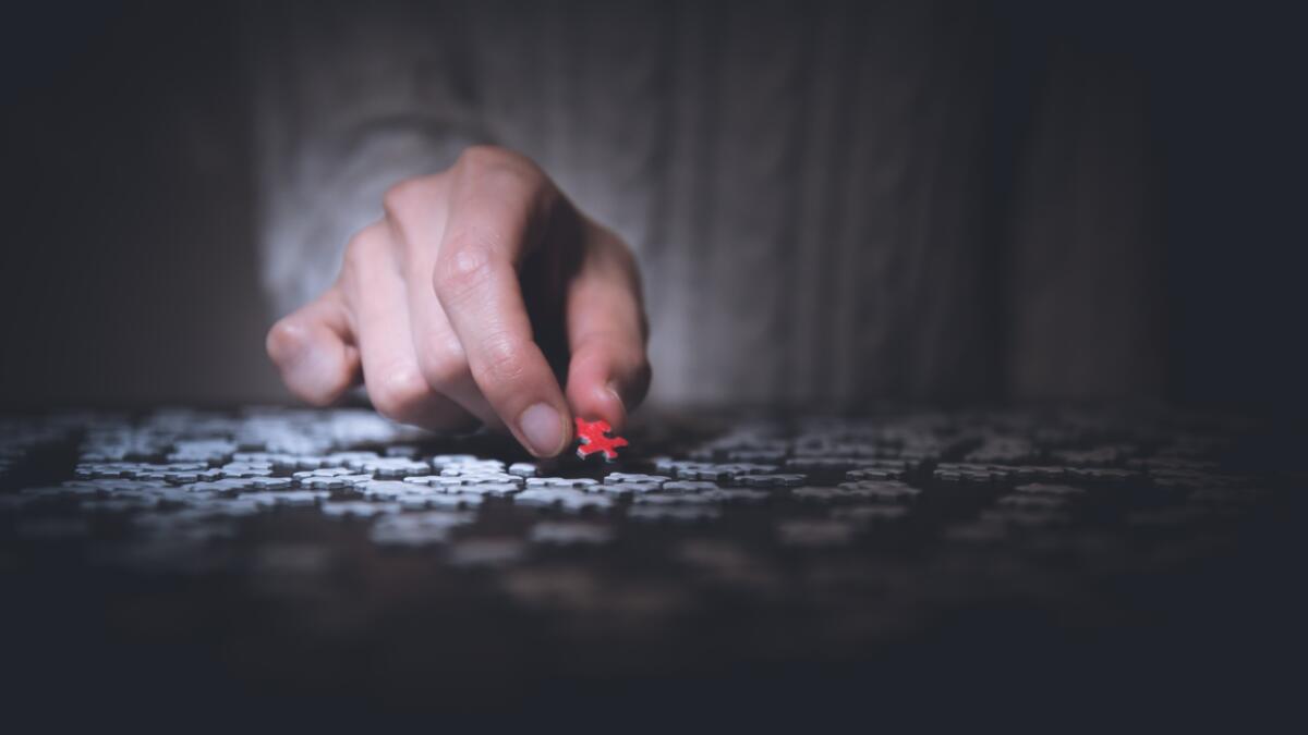 Eine Hand hält ein rotes Puzzleteil