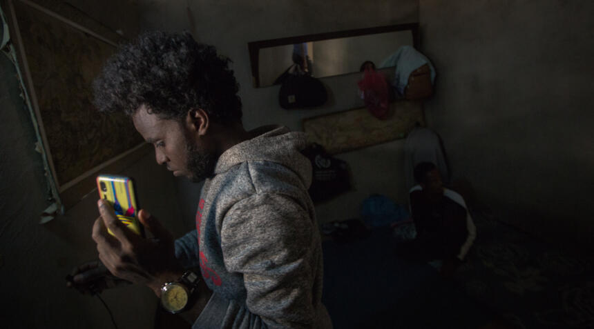 Flüchtender mit Handy in der Hand