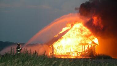 Feuerwehrmensch löscht brennendes Haus