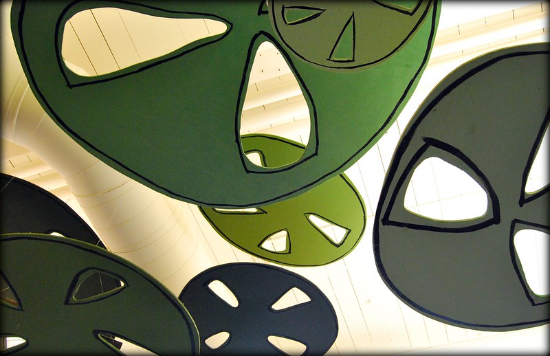 Eine Nahaufnahme mehrerer aus Pappe ausgeschnittener Zahnräder in verschiedenen Grüntönen.