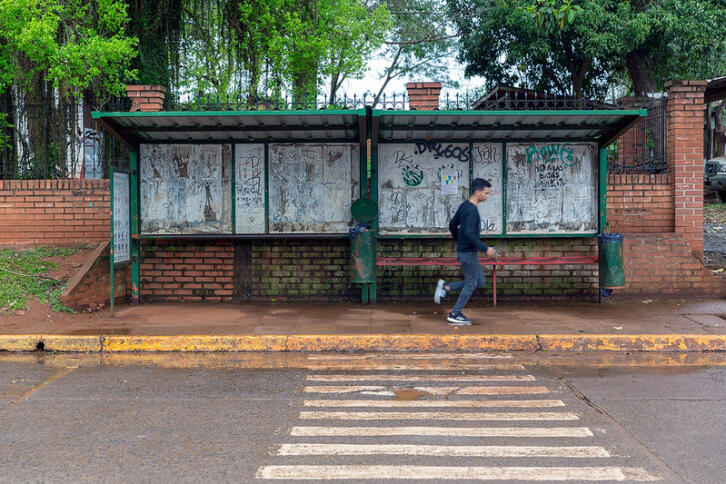 Eine Bushaltestelle, an der ein Mann vorbeirennt.