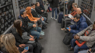 Menschen mit Smartphones in einer U-Bahn.