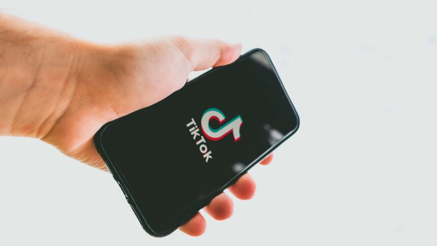 Hand hält Smartphone mit TikTok Logo