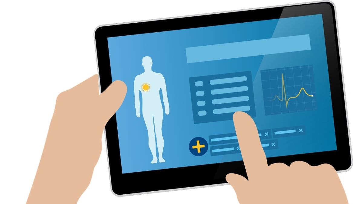 Eine Hand bedient ein Tablet, auf dem Gesundheitsdaten zu sehen sind.