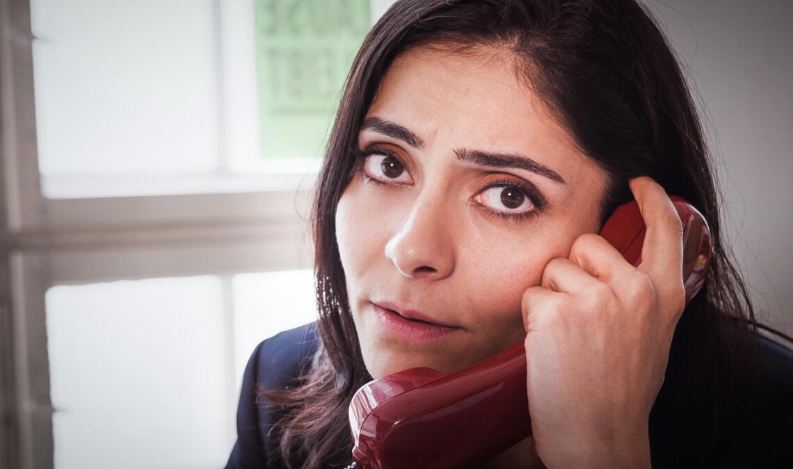 Frau mit Telefonhörer in der Hand