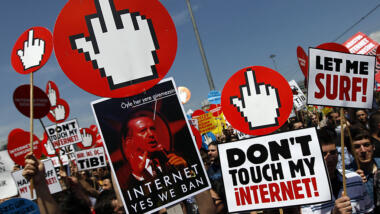 Bild von einer Demonstration. Zu sehen sind mehrere Schilder, unter anderem ein Bild von Präsident Erdogan und ein Schriftzug "Dont Touch my Internet".