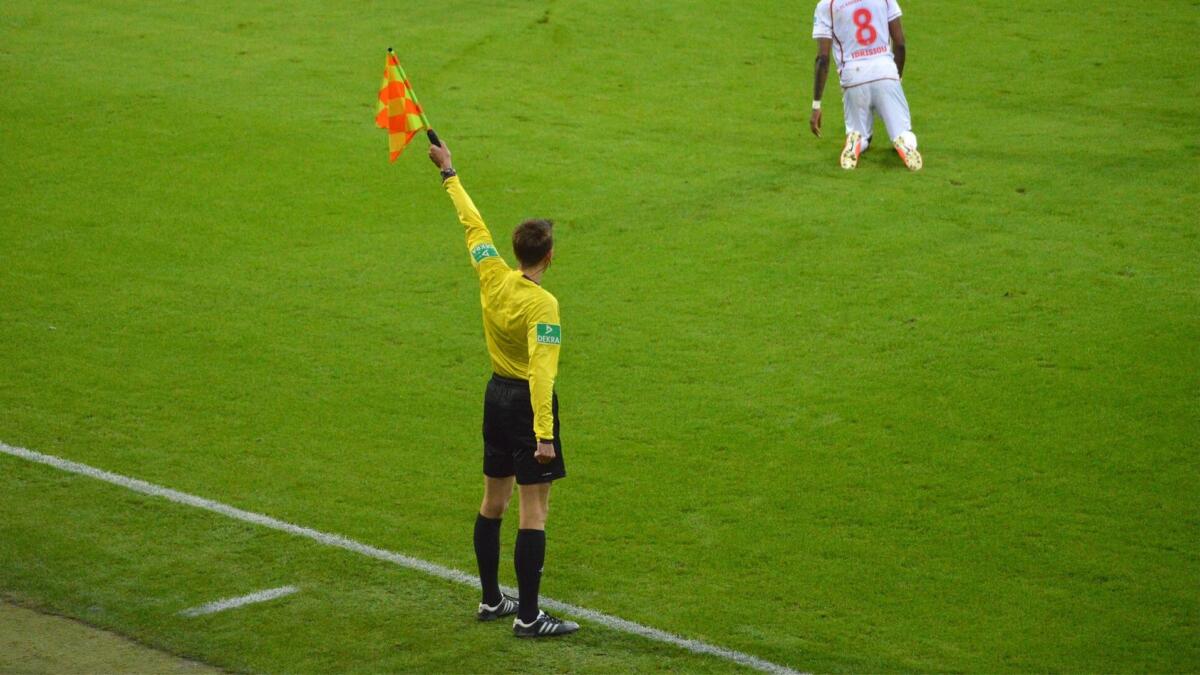 Ein Linienrichter an der Seitenlinie hebt die Fahne.