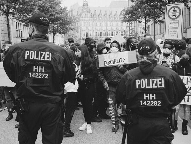 Polizist:innen stehen von einer Demonstration