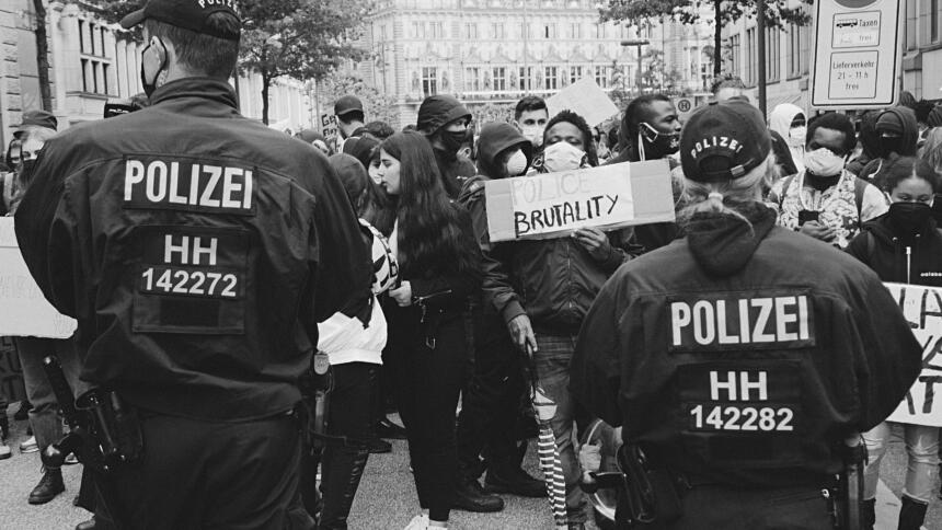 Polizist:innen stehen von einer Demonstration