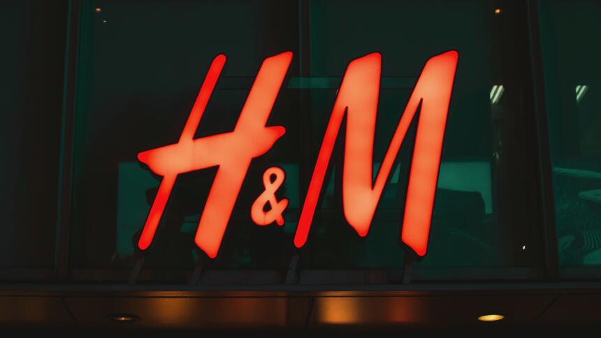 Das H&M Logo leuchtet an einem dunklen Gebäude
