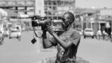 Ein Mann hält eine Kamera, schwarz-weiß-Fotografie