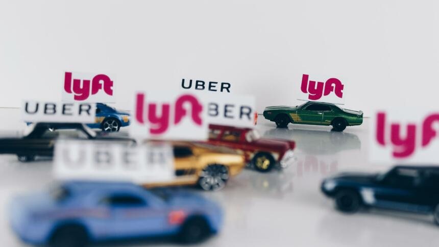 Spielzeugautos mit kleinen Flaggen der Logos von Lyft und Uber.