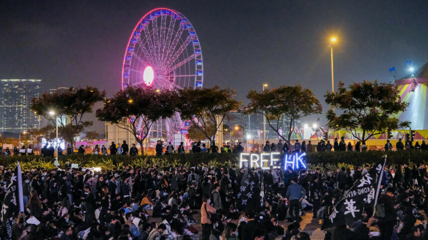 Demonstration mit Leuchtschrift "Free HK", im Hintergrund ein beleuchtetes Riesenrad