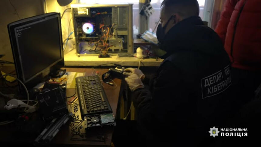 Ukrainischer Polizist sitzt vor Rechner