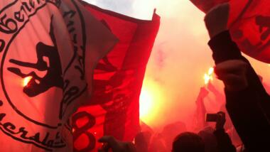 Fans des 1. FC Kaiserslautern mit Pyrotechnik, Fahnen und gereckten Fäusten.