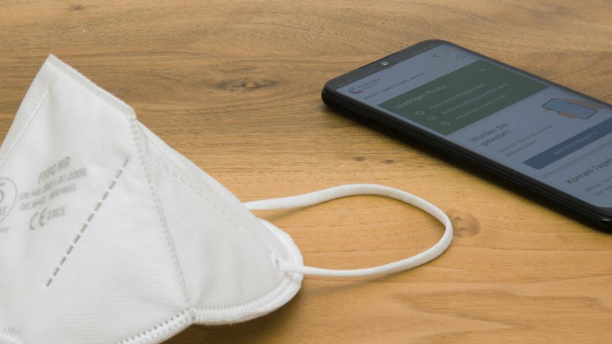 Handy und Maske liegen auf dem Tisch