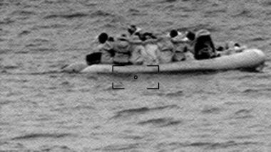 Das körnige Bild zeigt ein Boot mit Geflüchteten.
