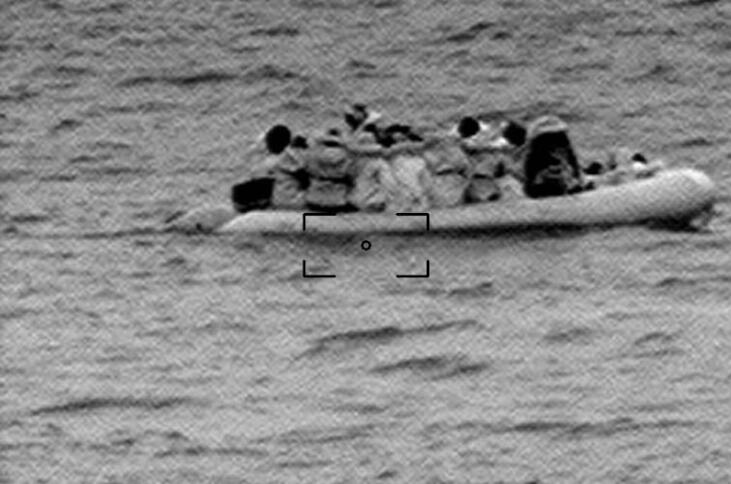 Das körnige Bild zeigt ein Boot mit Geflüchteten.