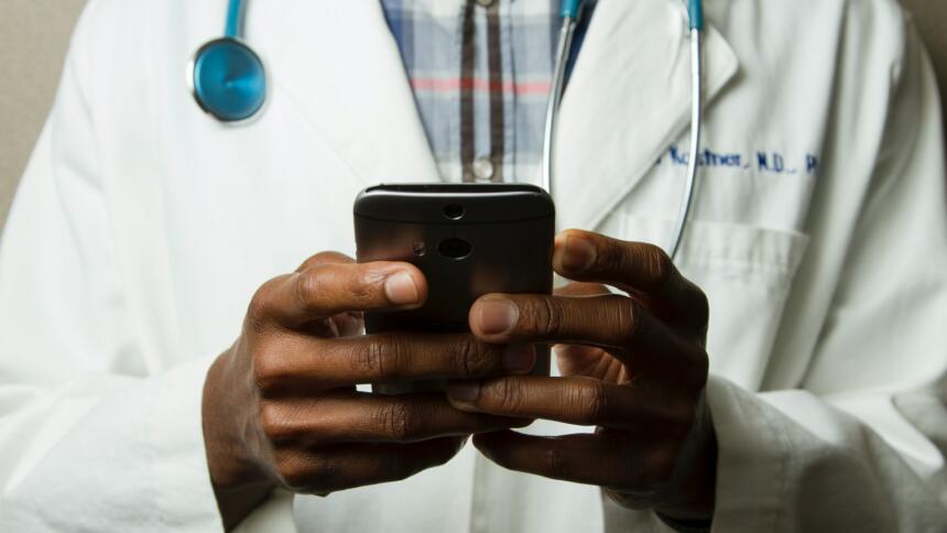 Ein Doktor mit Stethoskop und Smartphone