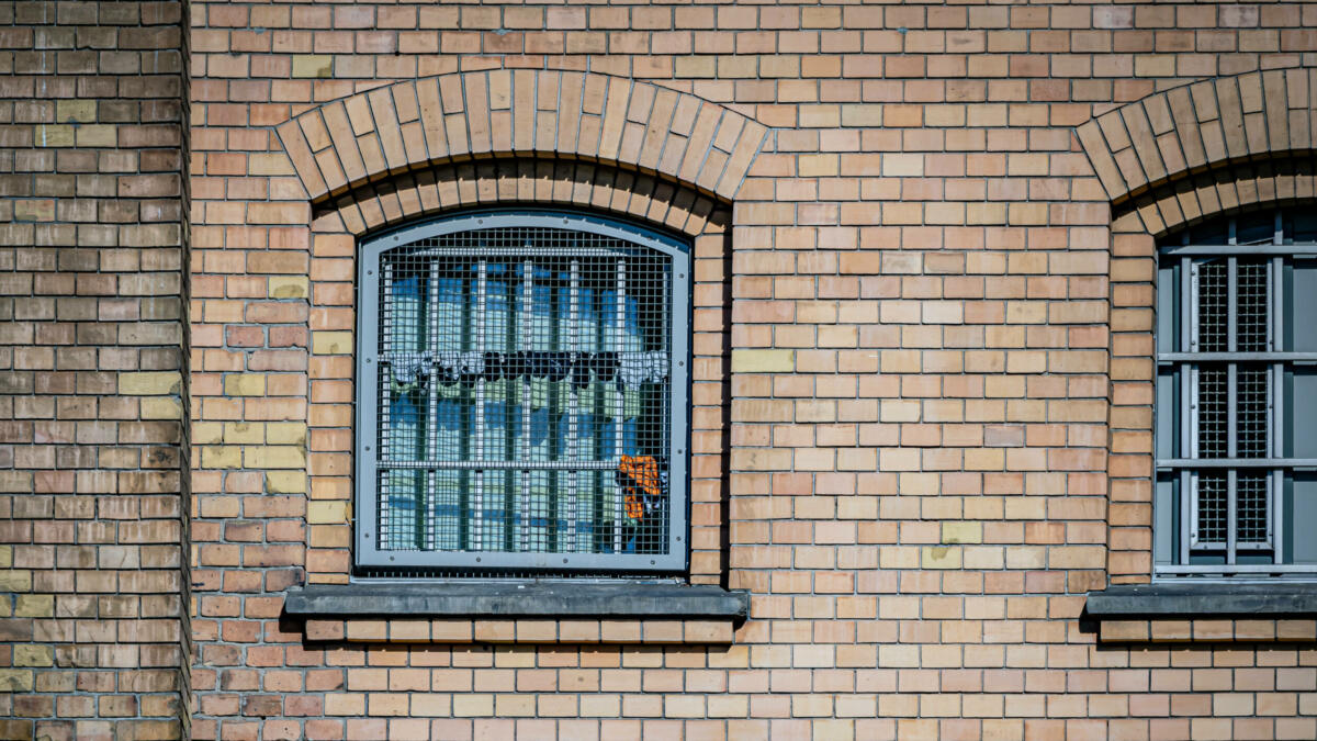 In einem vergitterten Fenster hängen Socken