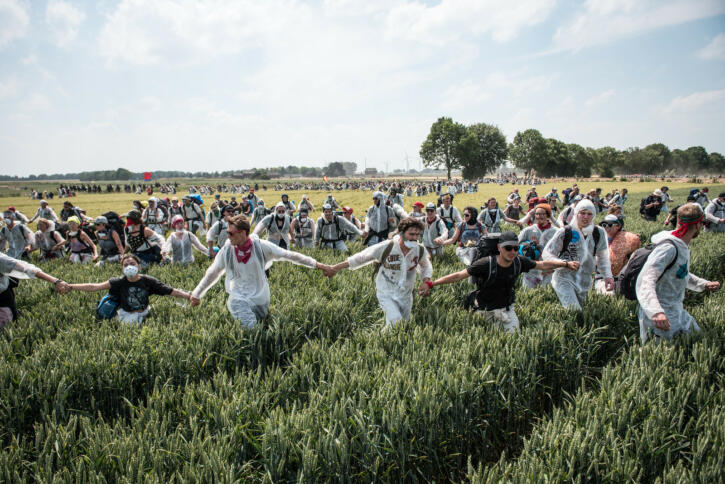 Menschen ziehen bei einem Protest über Felder