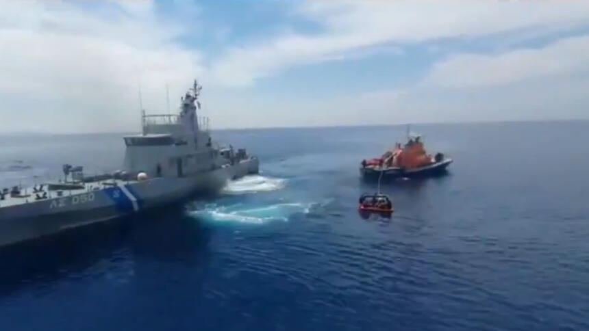 Das Bild zeigt zwei Schiffe der griechischen Küstenwache, von denen eines eine Rettungsinsel an einem Seil hinter sich herzieht.