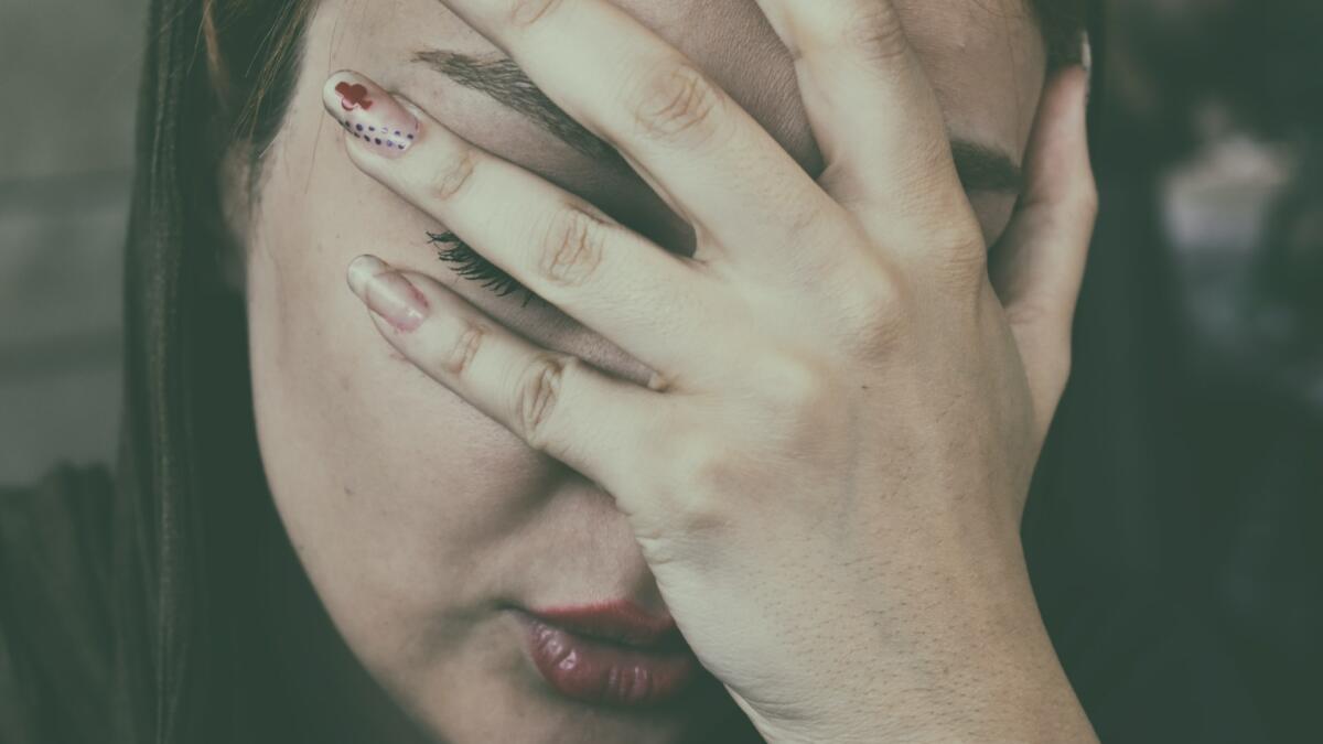 Frau hält sich Hand ins Gesicht